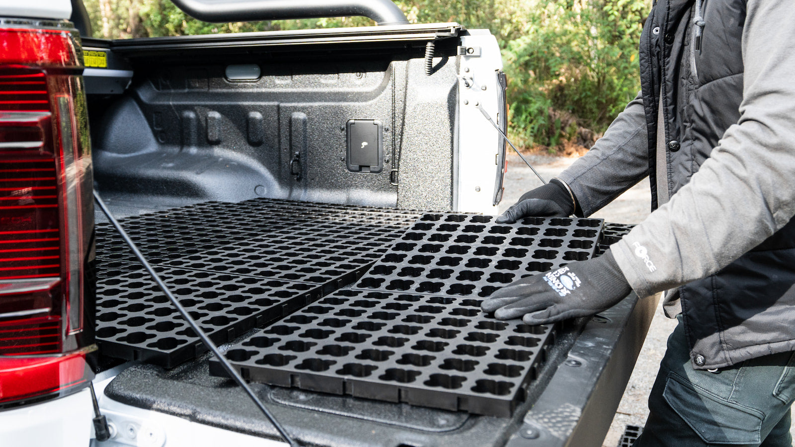 LockNMat tile being placed into a ute tray during installation